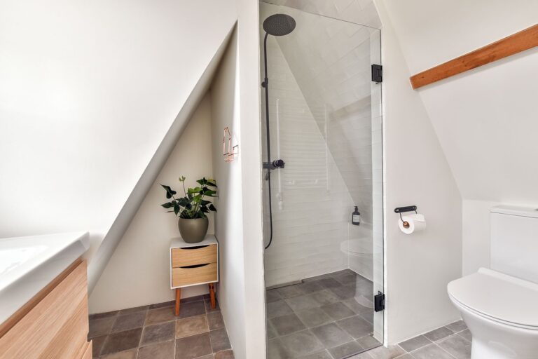 Clever use of space with a frameless glass shower cubicle tucked under the stairs