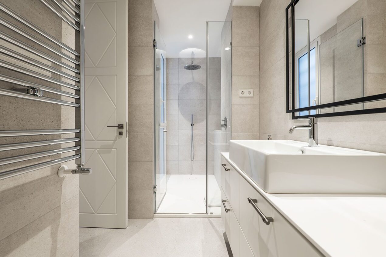 Bright contemporary bathroom with a frameless glass shower door and chrome towel rail