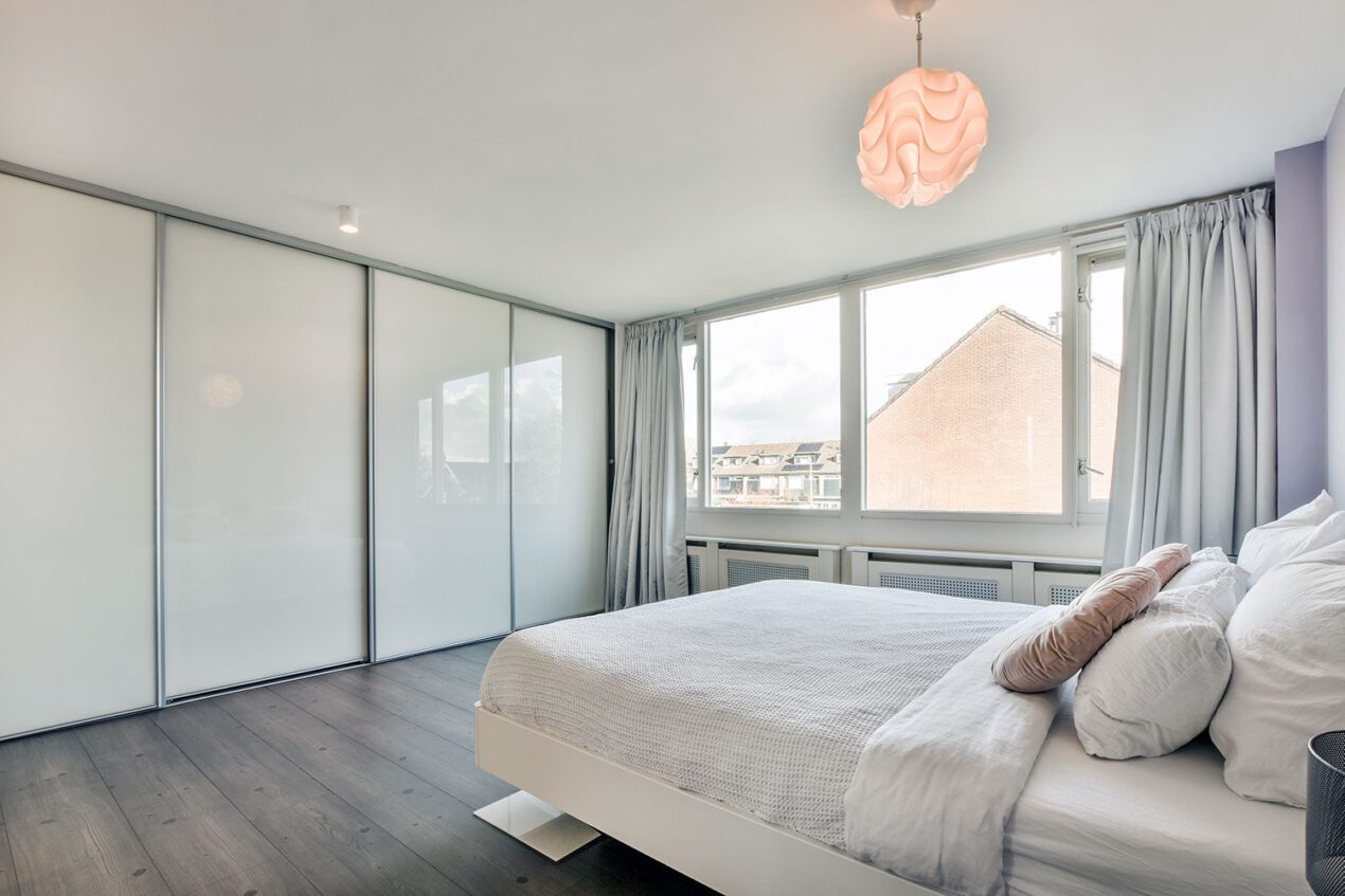 white glass sliding robe doors in modern gold coast bedroom