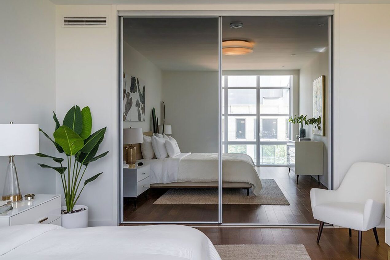 Bedroom with sleek mirror sliding doors on a built-in wardrobe for added light and space