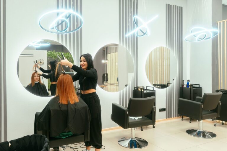 Gold Coast hair salon with round wall mirrors and hairdresser styling a client’s hair