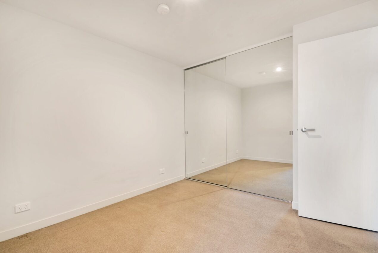 Frameless sliding mirror wardrobe doors in a empty bedroom
