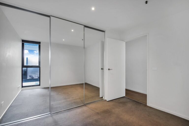 Sliding mirror wardrobe doors with silver frame in bedroom