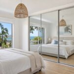 Mirror sliding wardrobe doors Gold Coast guide showing framed mirror panels in a bright bedroom