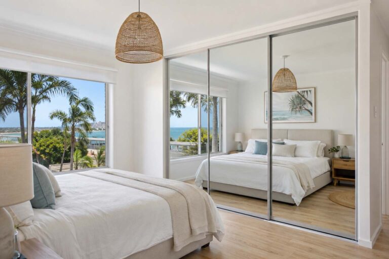 Mirror sliding wardrobe doors Gold Coast guide showing framed mirror panels in a bright bedroom