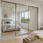Sliding wardrobe door cost Gold Coast guide showing custom mirror doors in a contemporary bedroom