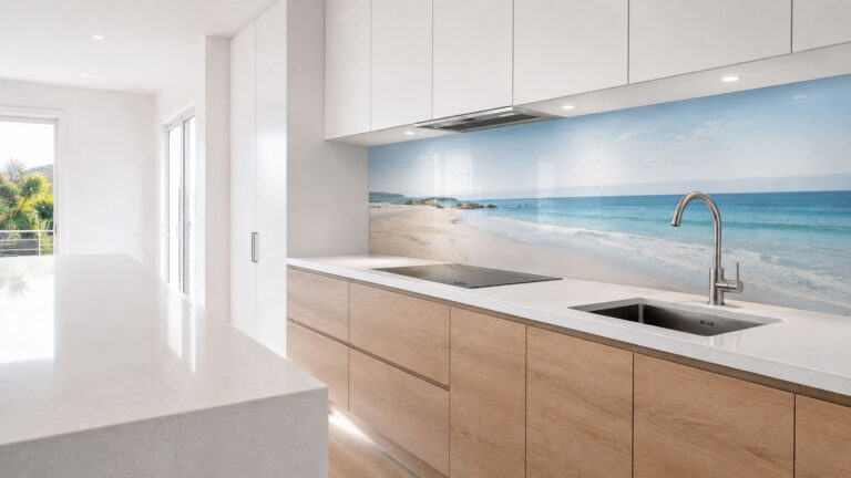 Custom printed glass splashback with a coastal image in a bright white kitchen with timber cabinetry