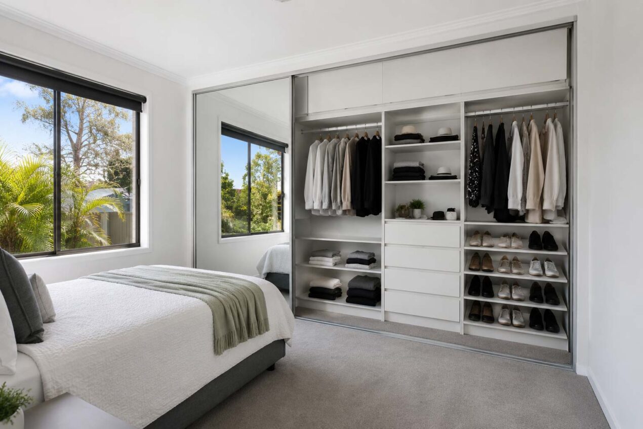 Built-in wardrobe cost example with sliding mirror doors and white melamine storage in a Gold Coast bedroom
